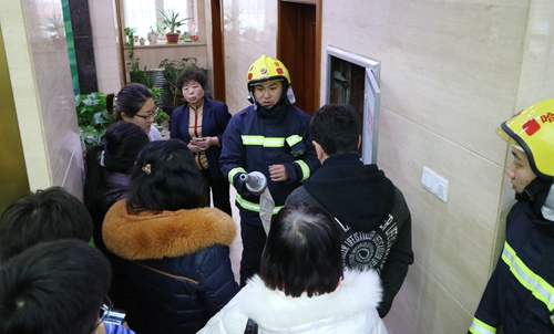 消防官兵讲解留学生公寓内消防设施的使用方法